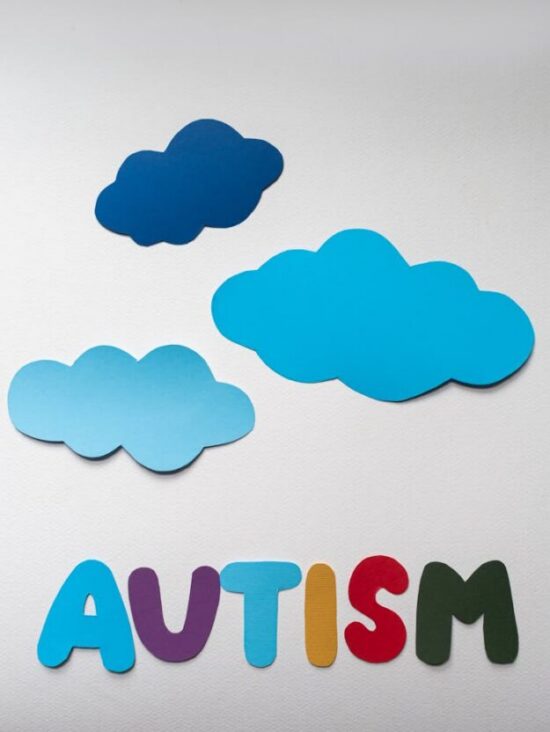 Creative autism awareness design with vibrant cloud cutouts on white background.